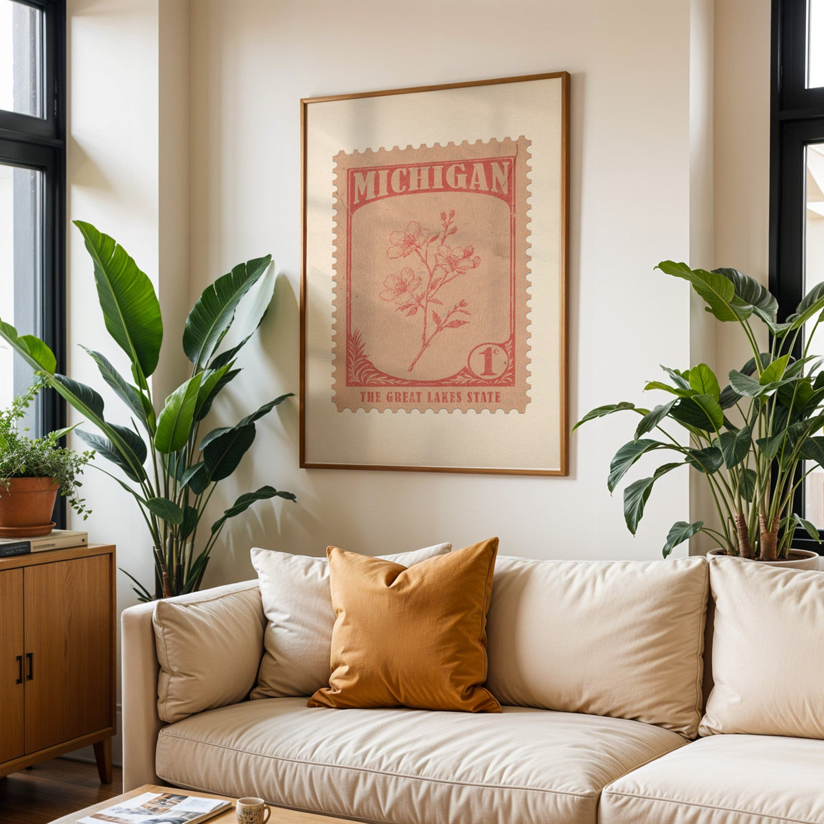 Michigan state flower print framed above a cream sofa with an ochre cushion and large plants either side