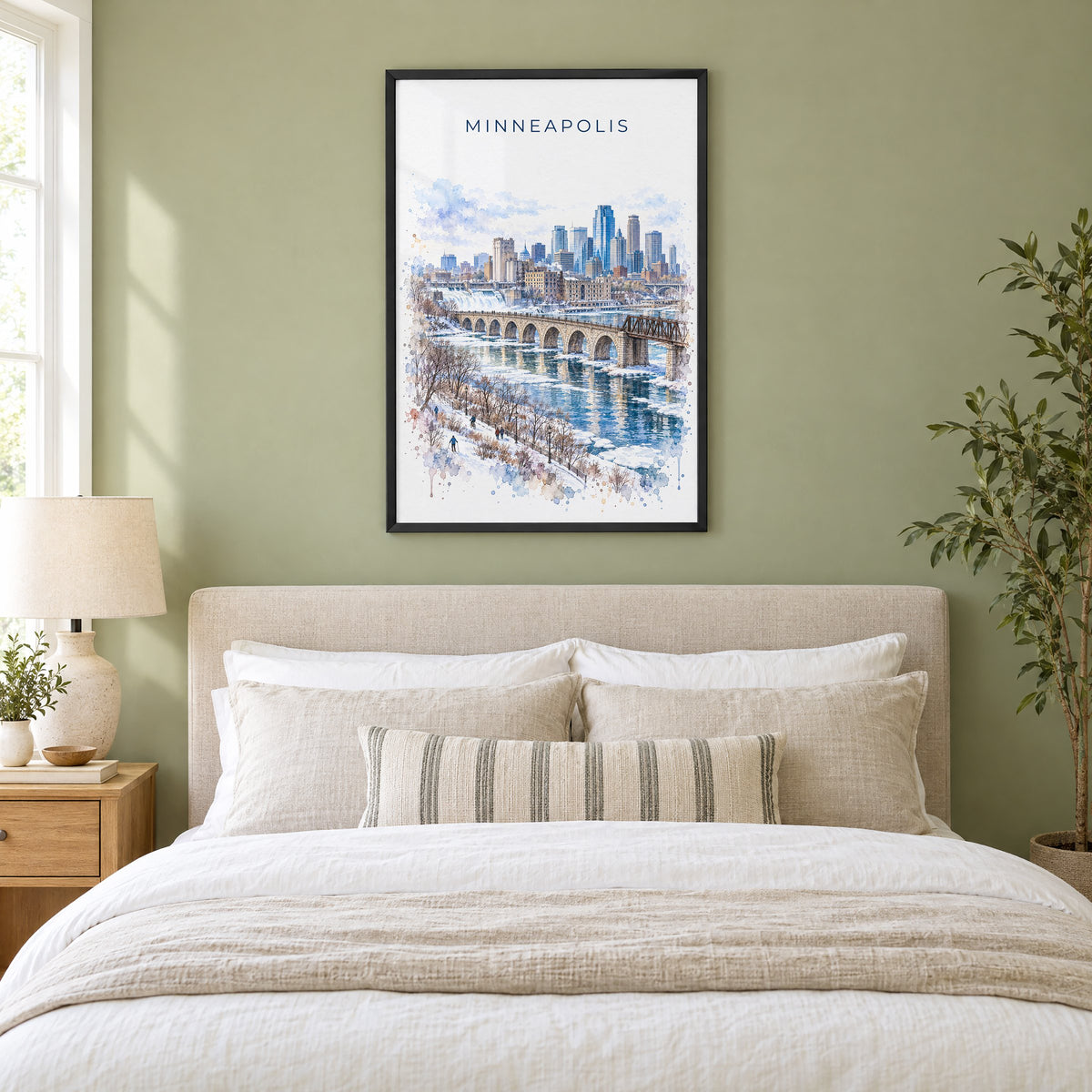 Minneapolis watercolor print in a black frame above an upholstered headboard in a sage green bedroom