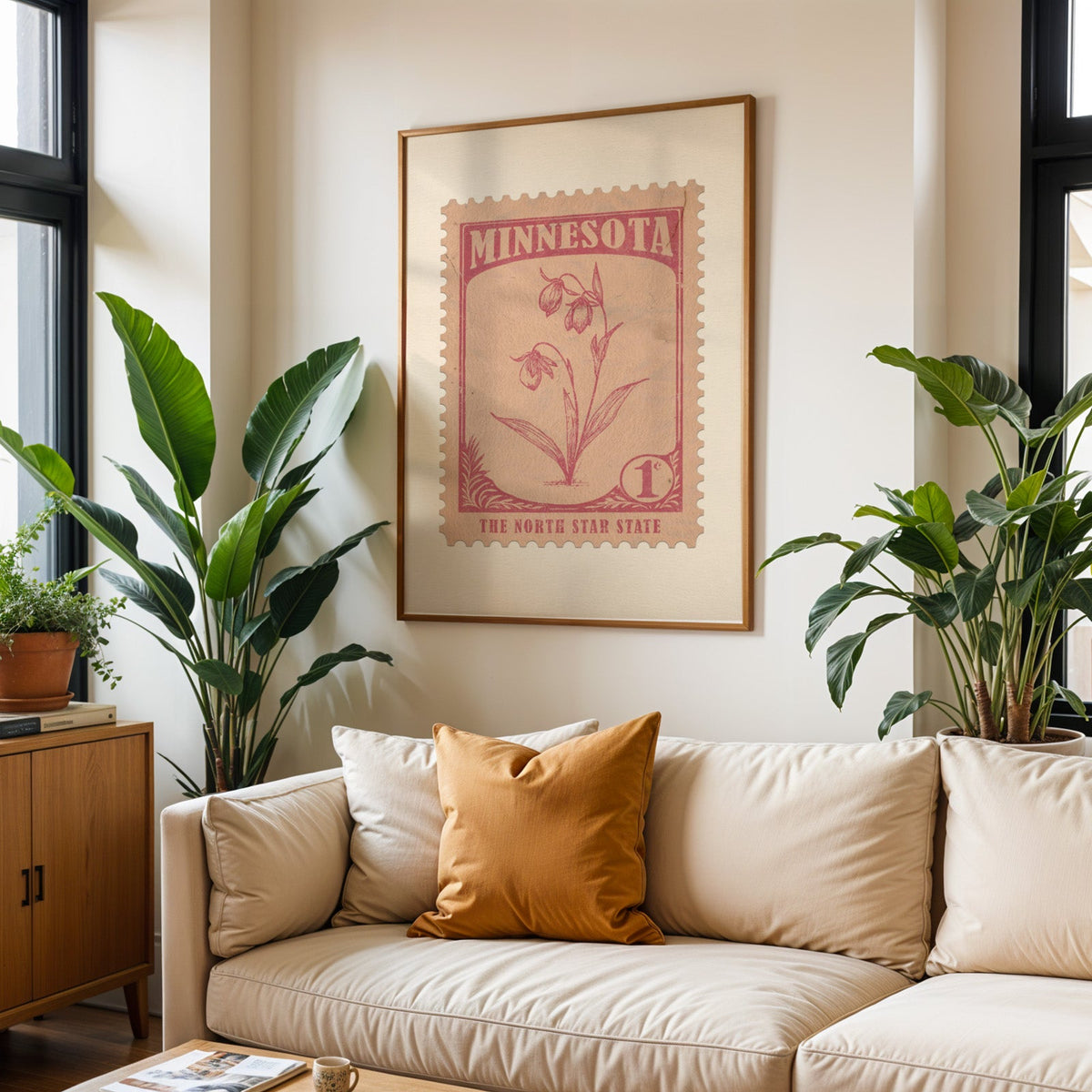 Minnesota state flower print framed above a cream sofa with an ochre cushion and large plants either side