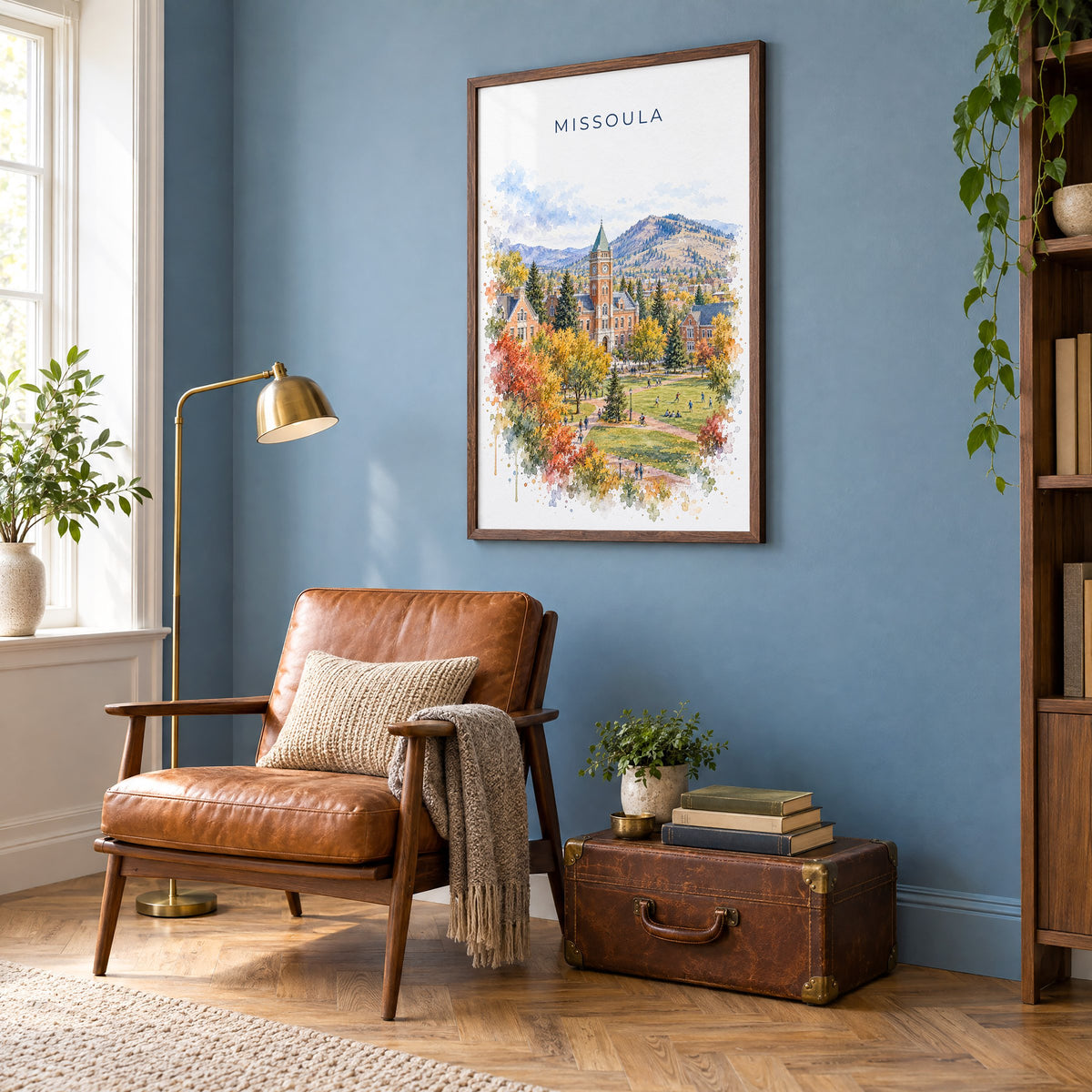 Missoula watercolor print in a walnut frame on a blue wall above a leather armchair in a reading nook
