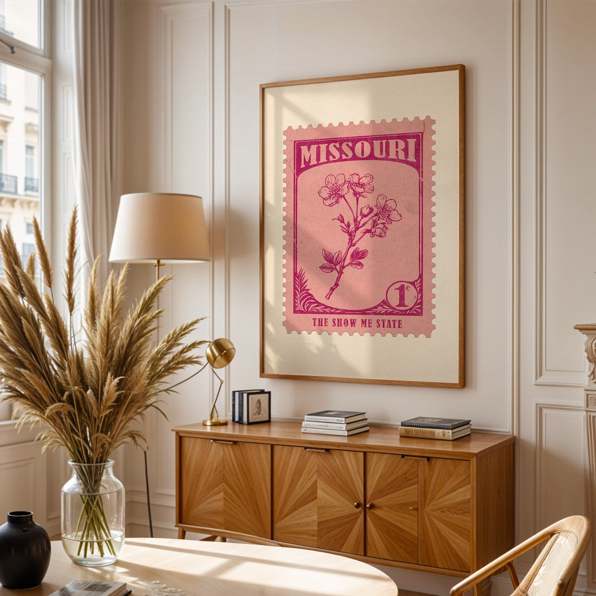 Missouri stamp print framed above a wooden sideboard, pampas grass in a glass vase and a floor lamp