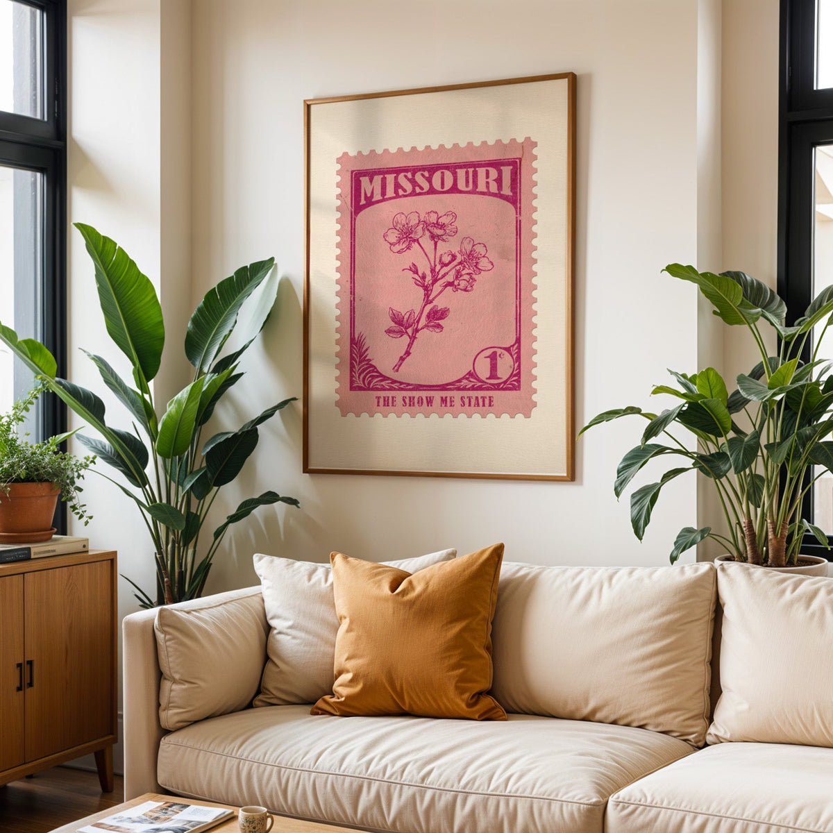 Missouri state flower print framed above a cream sofa with an ochre cushion and large plants either side
