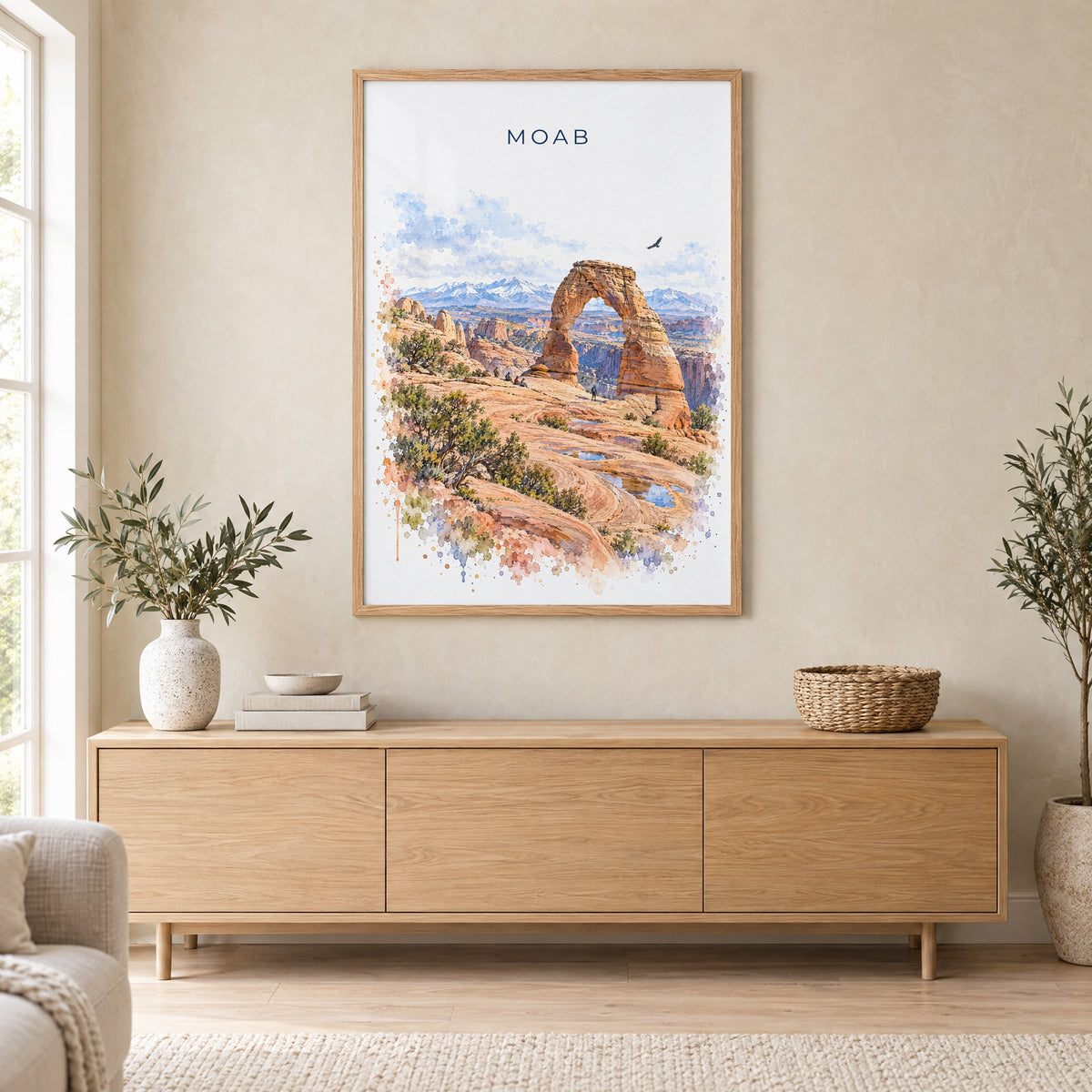 Moab watercolor print in an oak frame above a light wood sideboard in a Scandinavian living room