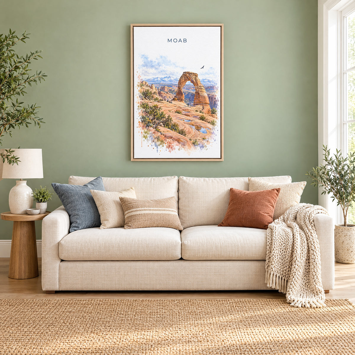 Moab watercolor print as a natural floater canvas above a cream linen sofa on a sage green wall
