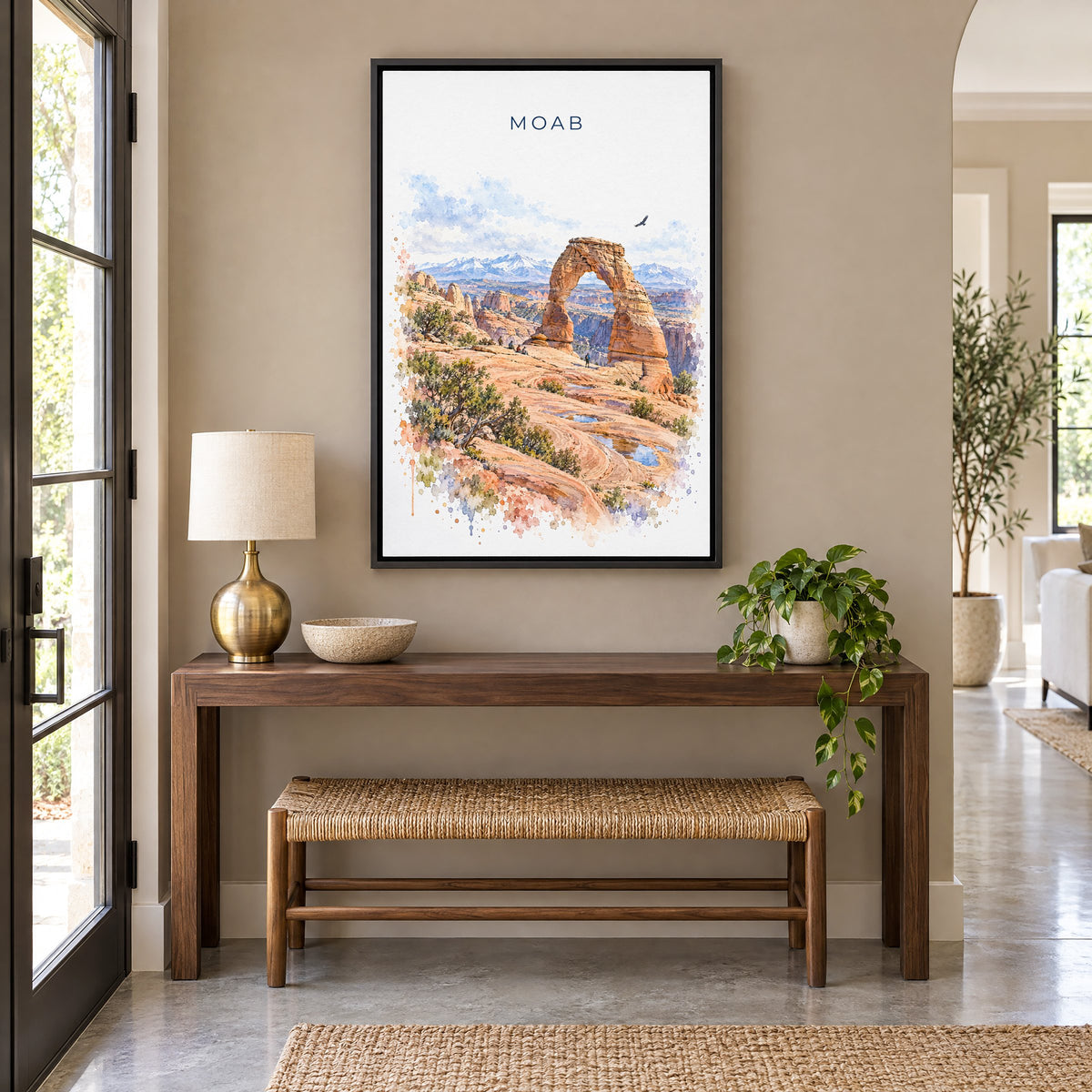 Moab watercolor print as a black floater canvas above a walnut console and woven bench in an entryway