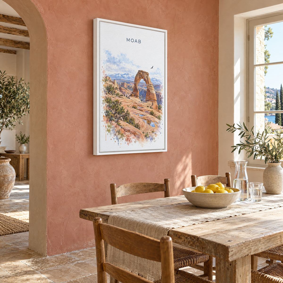 Moab watercolor print as a white floater canvas on a terracotta wall above a rustic dining table