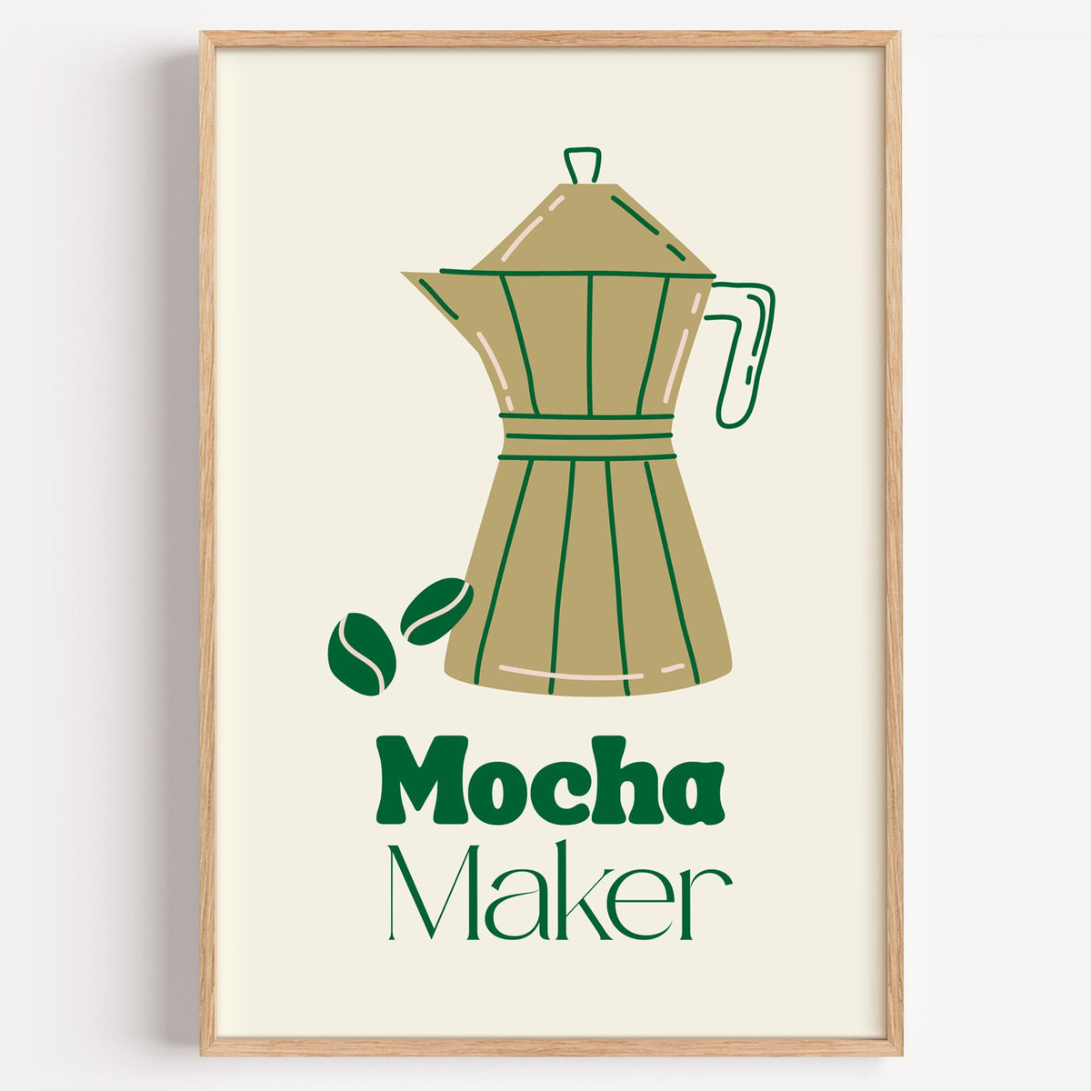 Mocha Maker gold moka pot and beans print in a light oak frame on a plain white wall
