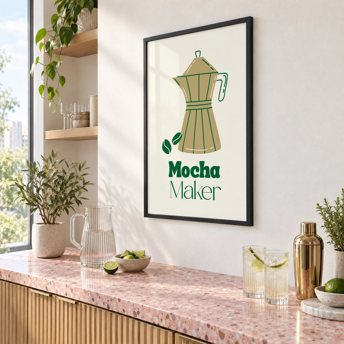Mocha Maker gold moka pot and beans print in a black frame above a pink terrazzo cocktail counter with limes, seen at an angle