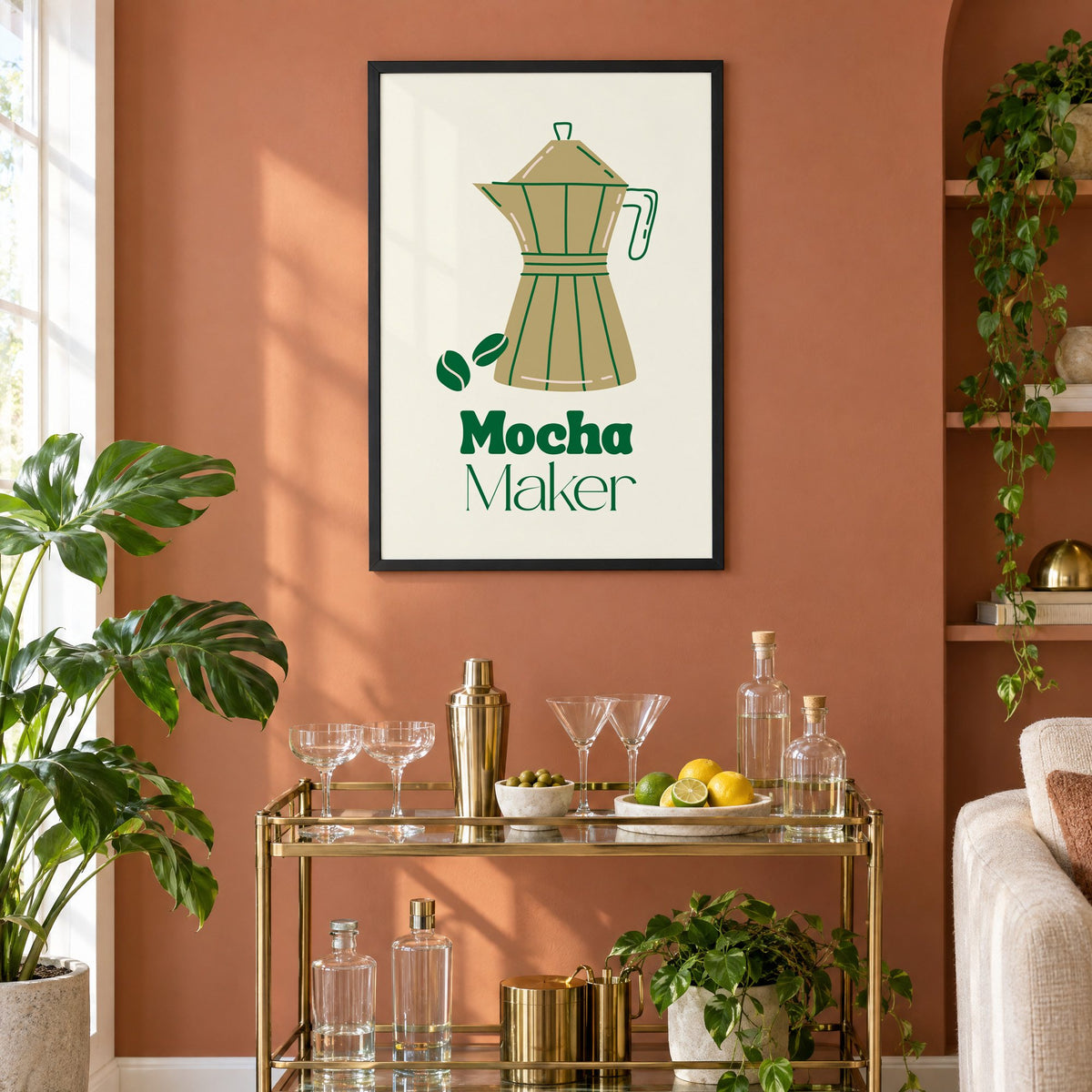 Mocha Maker gold moka pot and beans print in a black frame on a terracotta wall above a brass bar cart with coupes and citrus