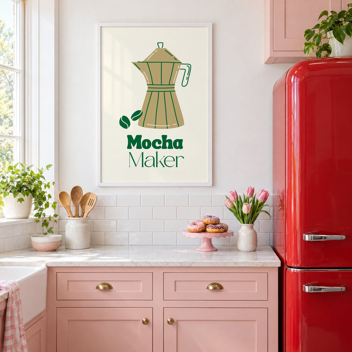 Mocha Maker gold moka pot and beans print in a white frame above pink cabinets beside a red retro fridge