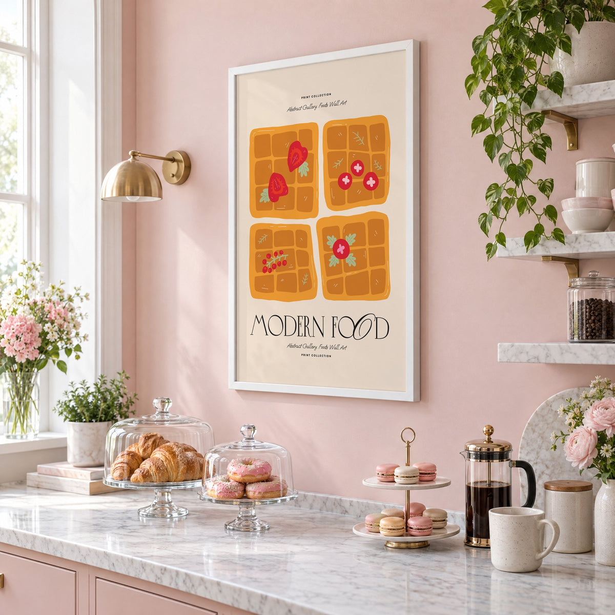MODERN FOOD four berry waffles print in a white frame on a blush pink wall above a patisserie counter with croissants and macarons, seen at an angle