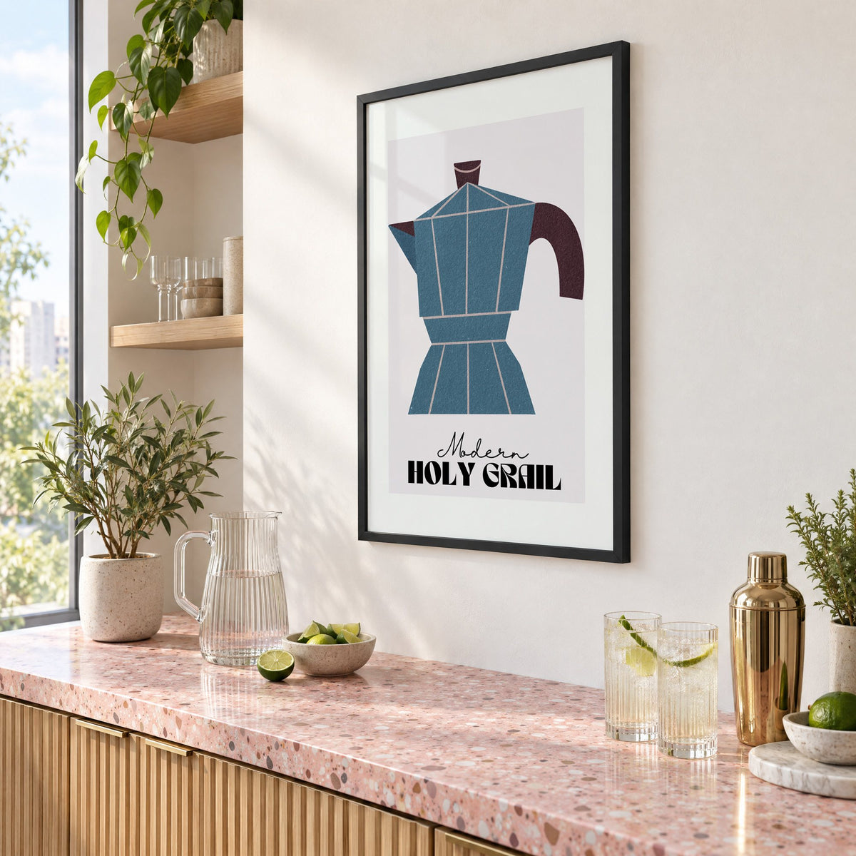 Modern Holy Grail moka pot print in a black frame above a pink terrazzo cocktail counter with limes, seen at an angle