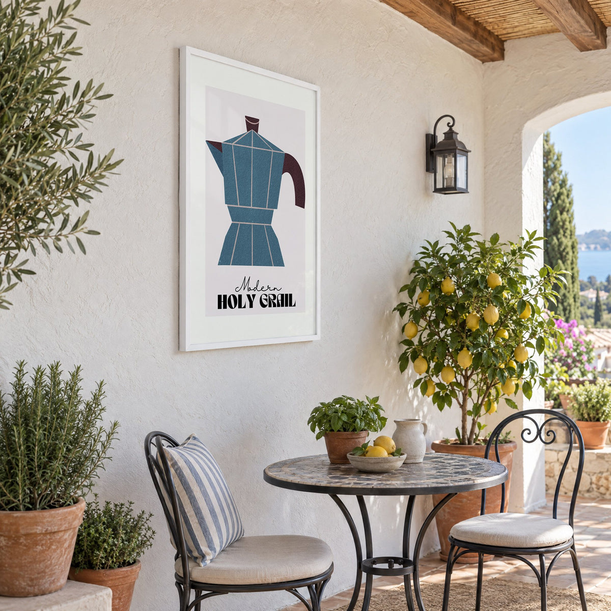 Modern Holy Grail moka pot print in a white frame on a sunny patio wall beside a potted lemon tree
