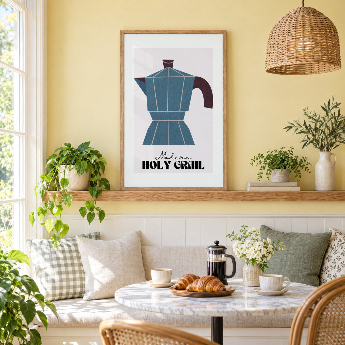 Modern Holy Grail moka pot print in an oak frame on a picture ledge above a sunny breakfast nook