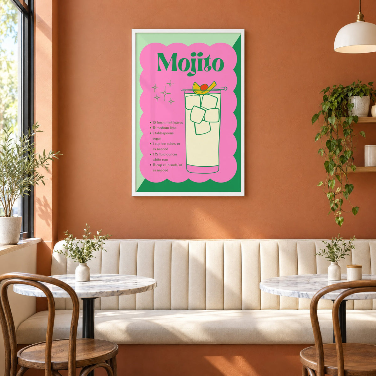 Mojito recipe retro scalloped print in a white frame above a cream banquette on a terracotta cafe wall