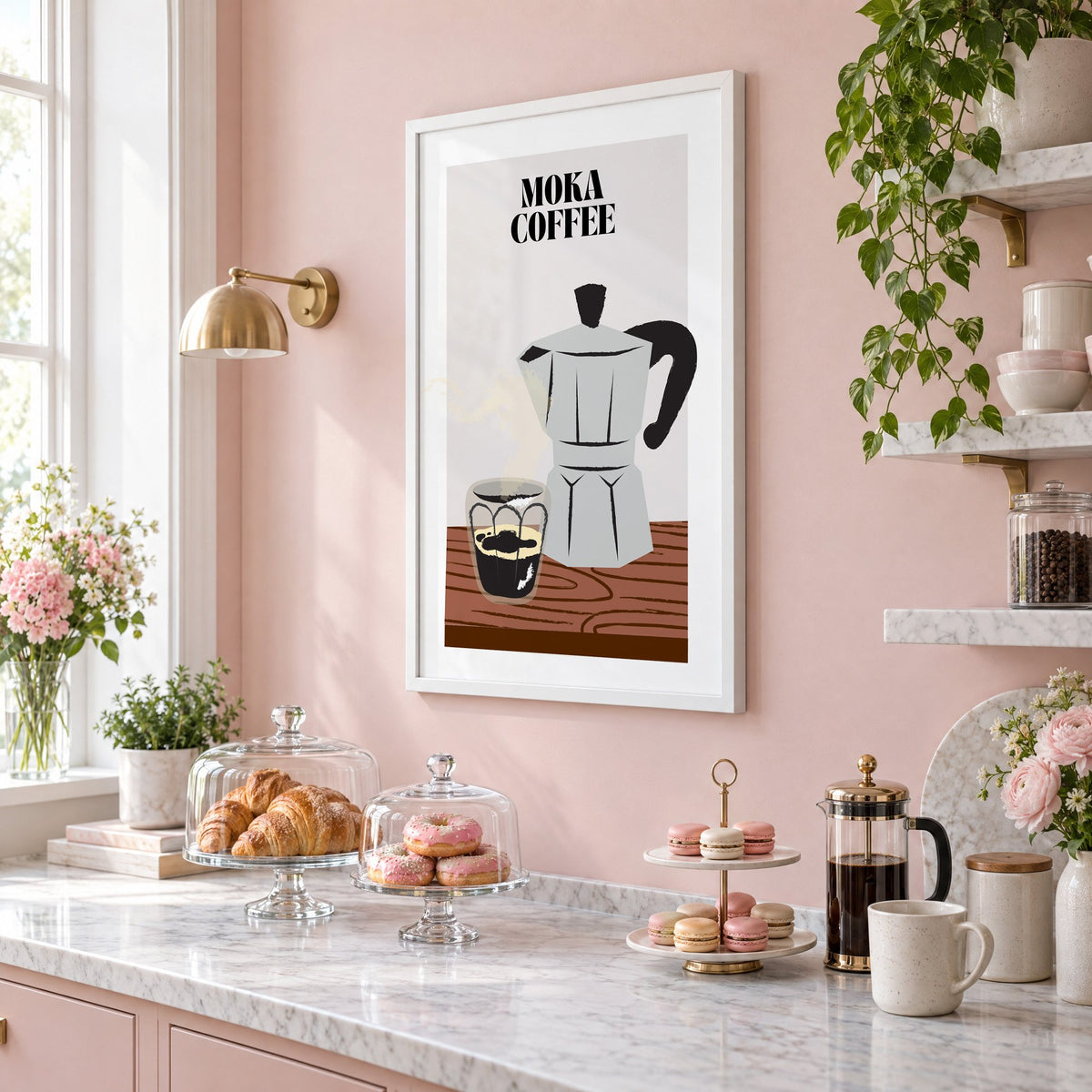 MOKA COFFEE silver pot wood table print in a white frame on a blush pink wall above a patisserie counter with croissants and macarons, seen at an angle