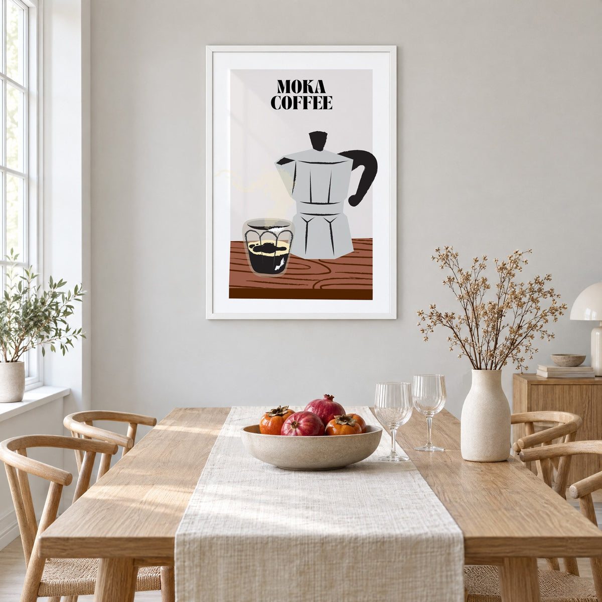 MOKA COFFEE silver pot wood table print in a white frame above a light oak dining table with a linen runner and fruit bowl