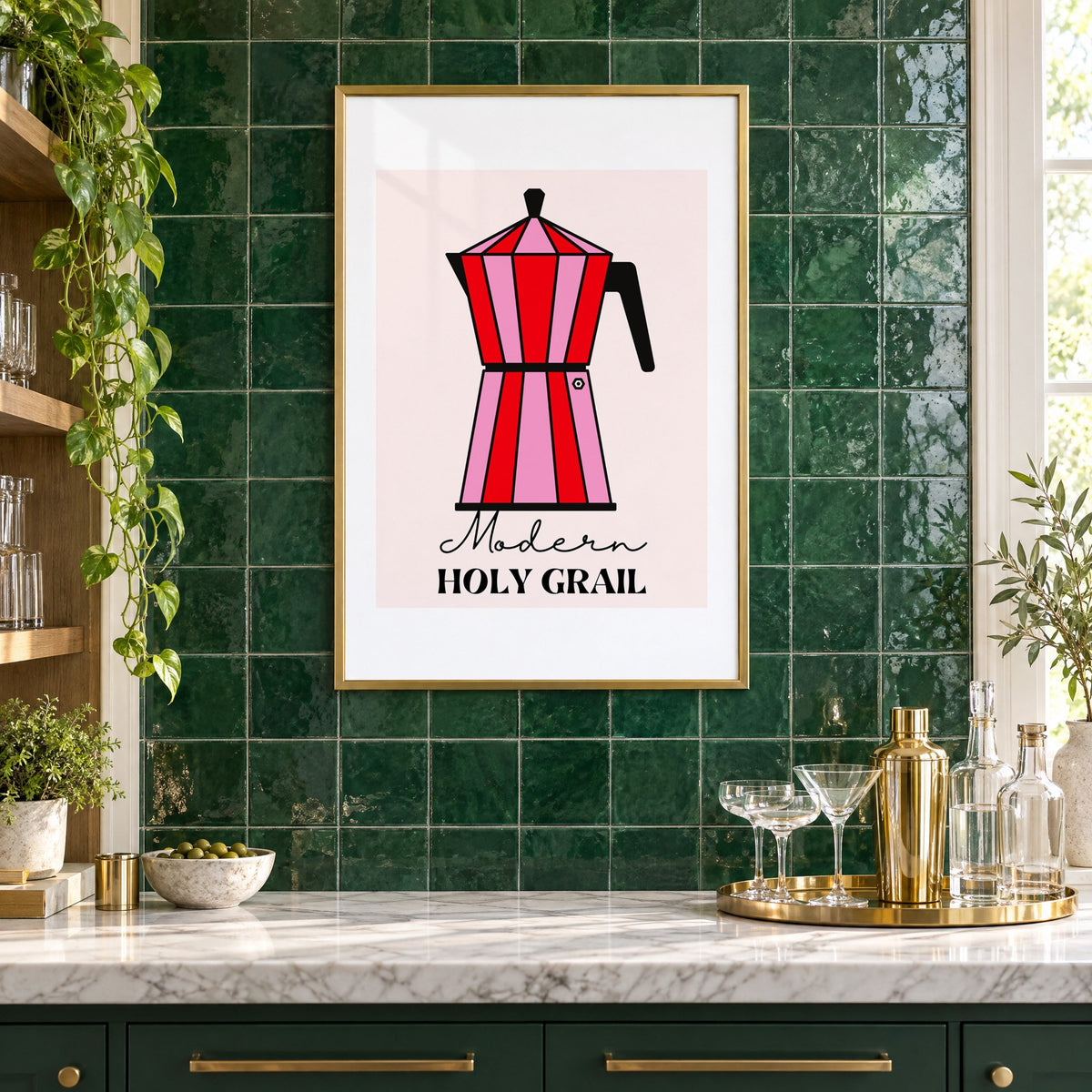 Moka pot pink and red striped print in a brass frame on emerald green tiles above a home bar with coupe glasses
