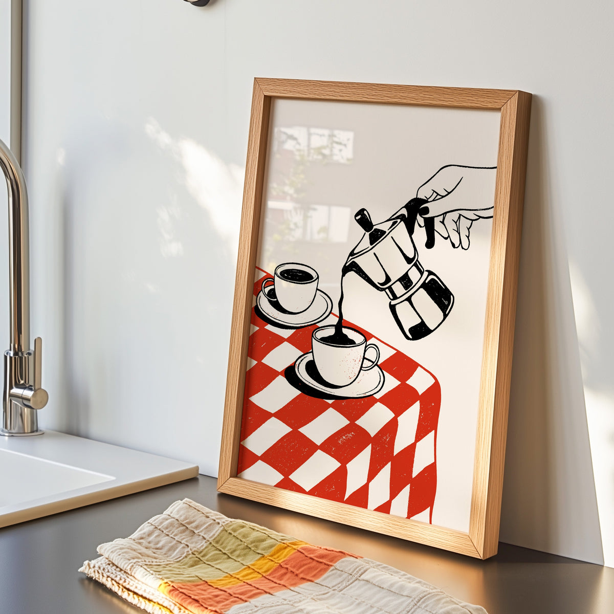 Moka pot print in an oak frame by the kitchen sink beside a striped tea towel