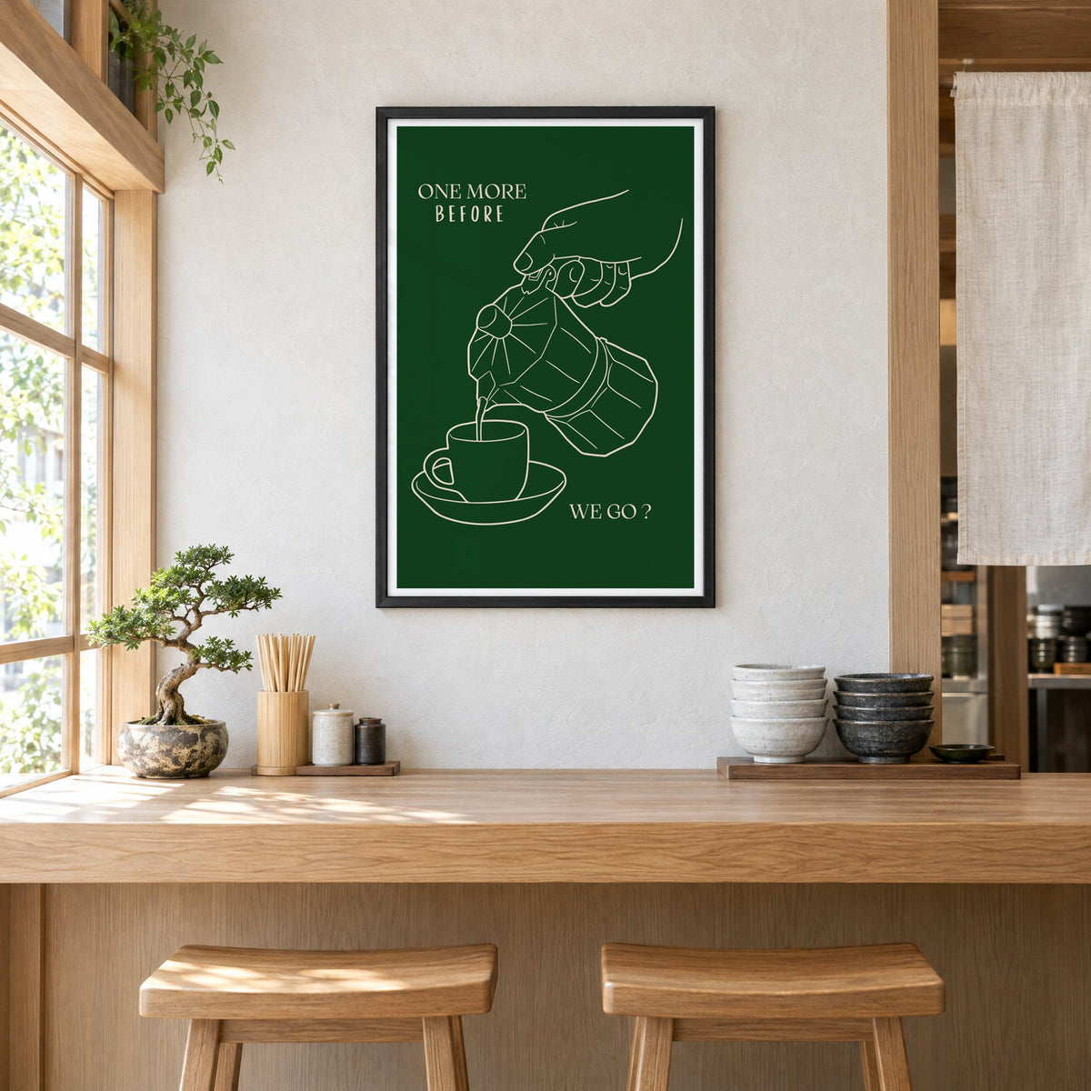 ONE MORE BEFORE WE GO? moka pot line print in a black frame above a light wood ramen counter with stools and stacked bowls