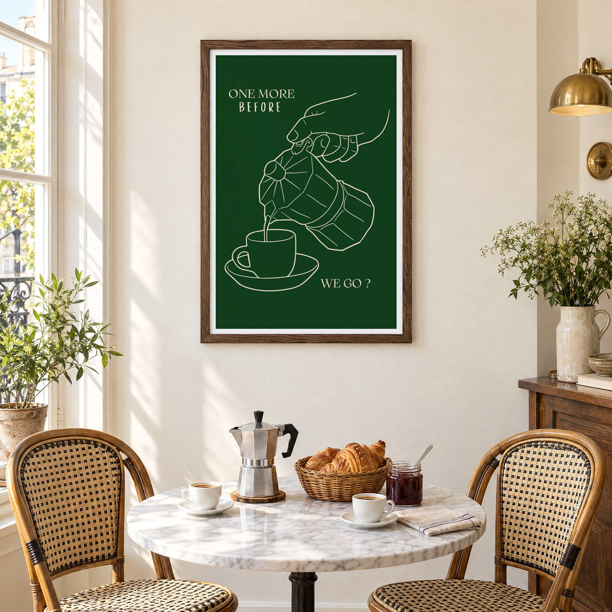 ONE MORE BEFORE WE GO? moka pot line print in a walnut frame above a marble bistro table with croissants and rattan chairs