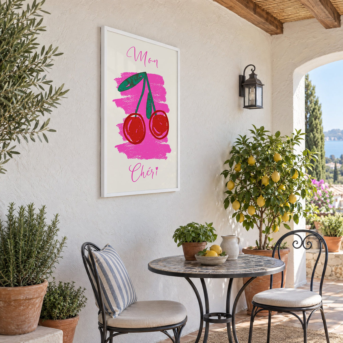 Mon Chéri cherries crayon print in a white frame on a sunny patio wall beside a potted lemon tree