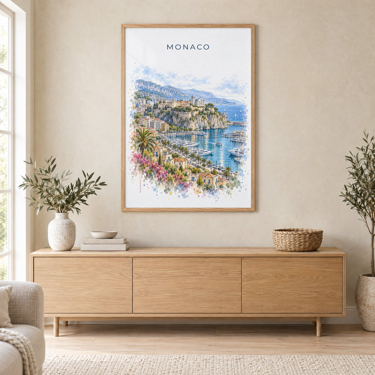 Monaco watercolor print in an oak frame above a light wood sideboard in a Scandinavian living room