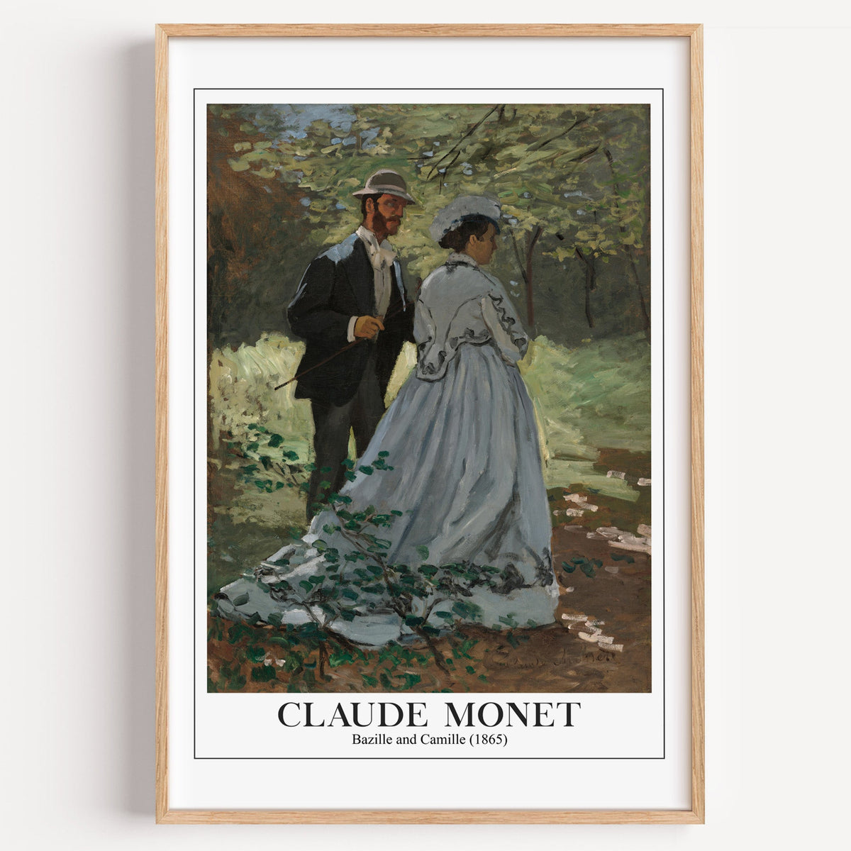 Monet Bazille and Camille print in a light oak frame on a plain white wall