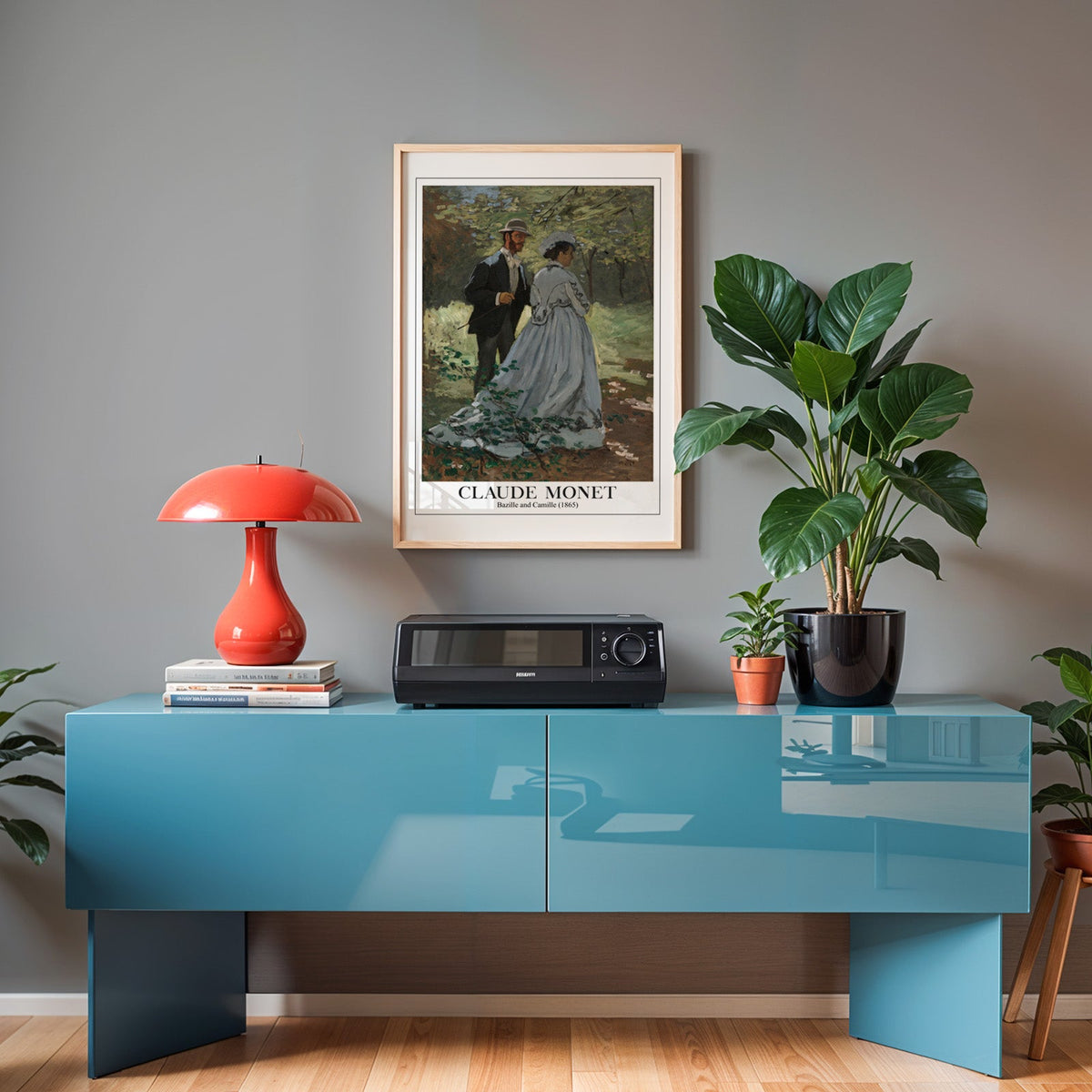 Monet impressionist poster in an oak frame above a teal sideboard with a red lamp