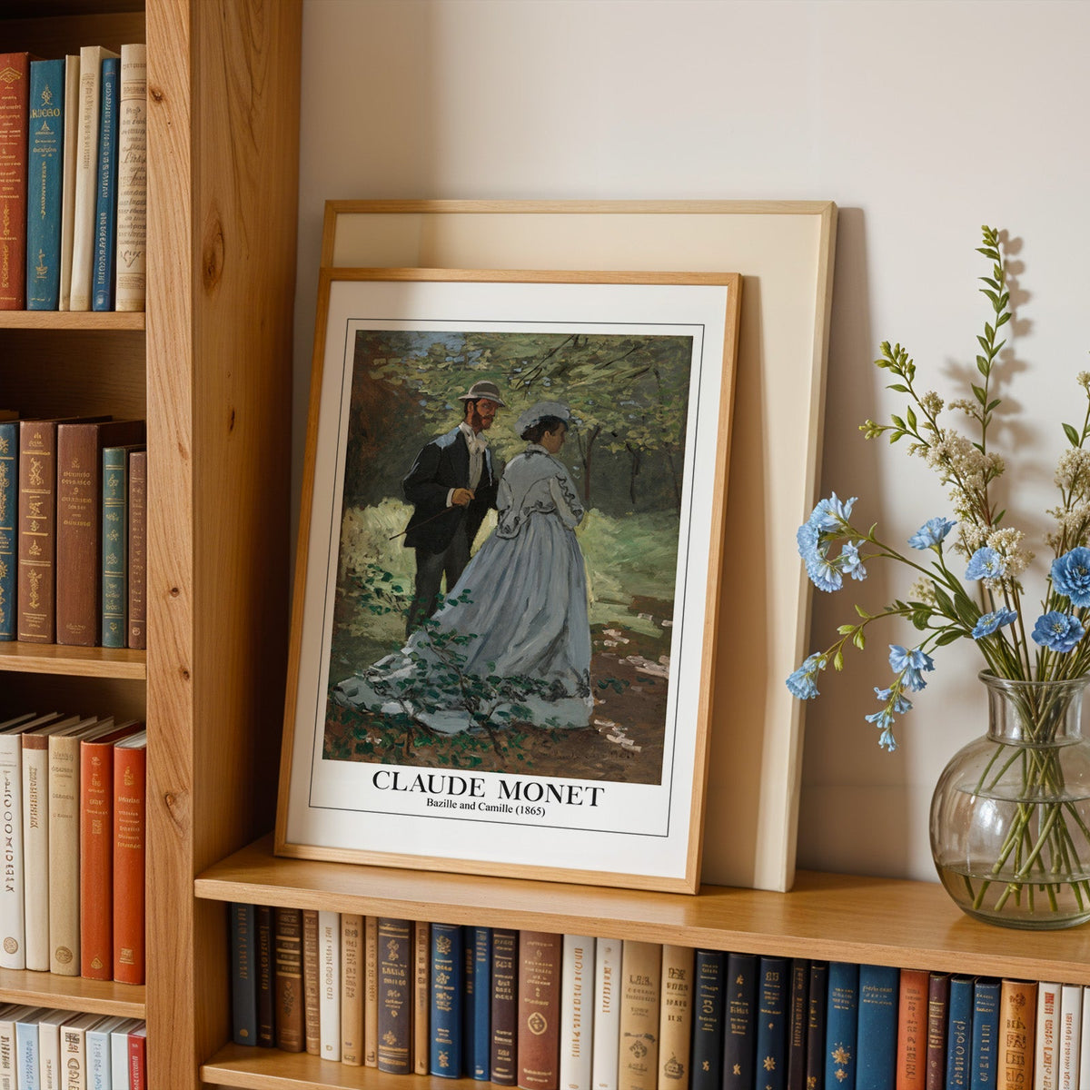 Monet print in an oak frame leaning on a bookshelf beside blue flowers