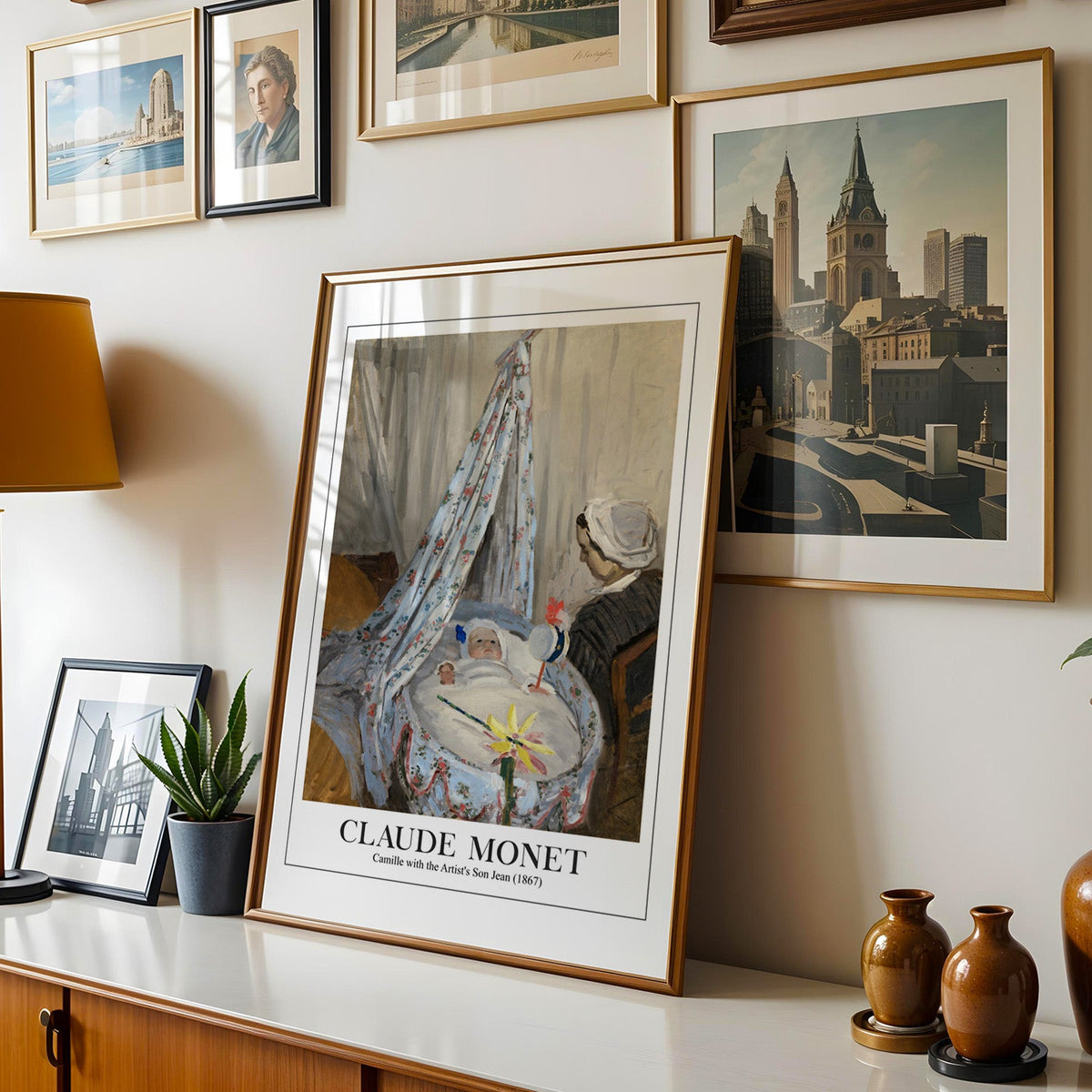 Monet print shown in a gold frame leaning on a sideboard in a gallery wall