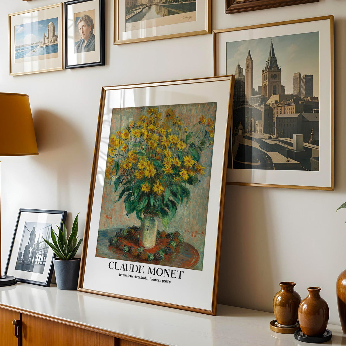 Monet floral print shown in a gold frame leaning on a sideboard in a gallery wall