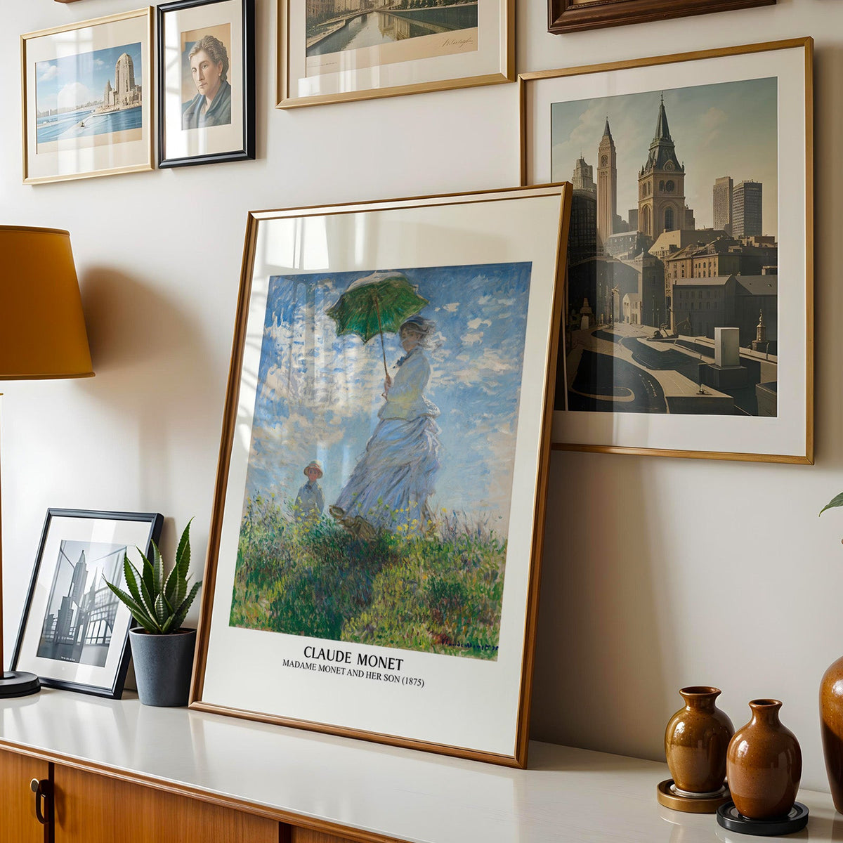 Monet parasol print shown in a gold frame leaning on a sideboard in a gallery wall