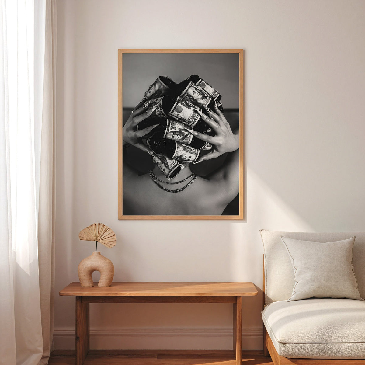 Hair curlers wrapped in dollar bills from behind print in an oak frame above a narrow console with an arched vase