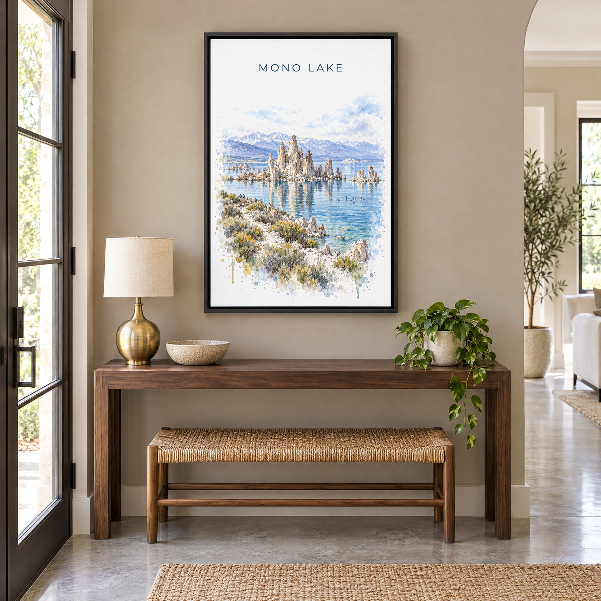 Mono Lake watercolor print as a black floater canvas above a walnut console and woven bench in an entryway