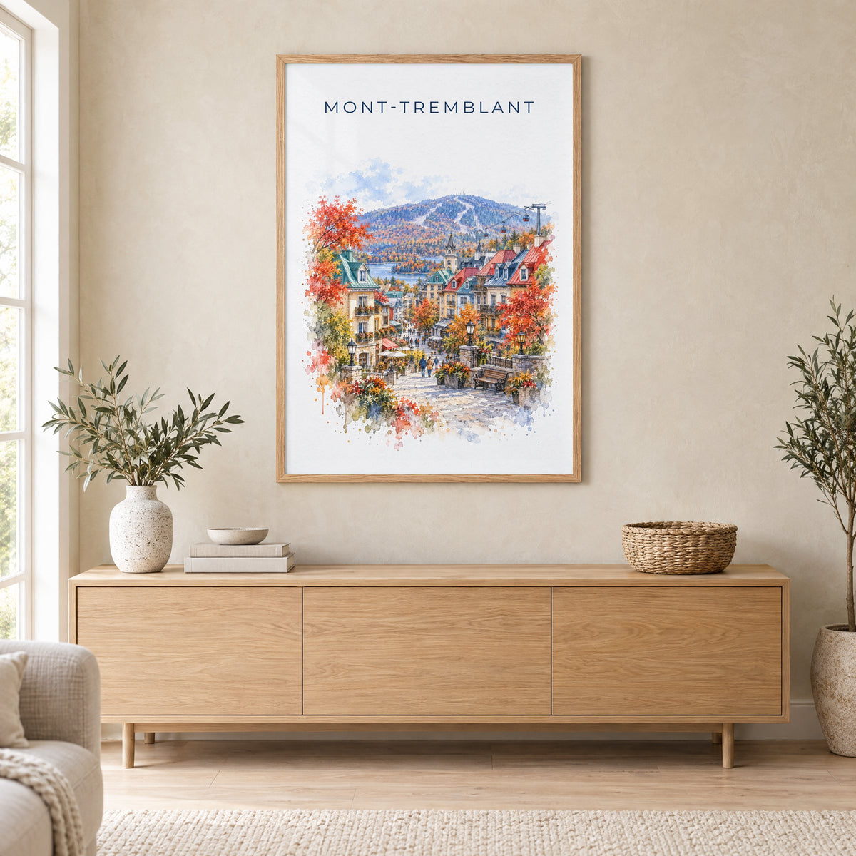Mont-Tremblant watercolor print in an oak frame above a light wood sideboard in a Scandinavian living room