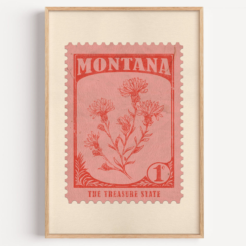 Montana state flower stamp print in vermilion on warm pink, light oak frame on a plain white wall