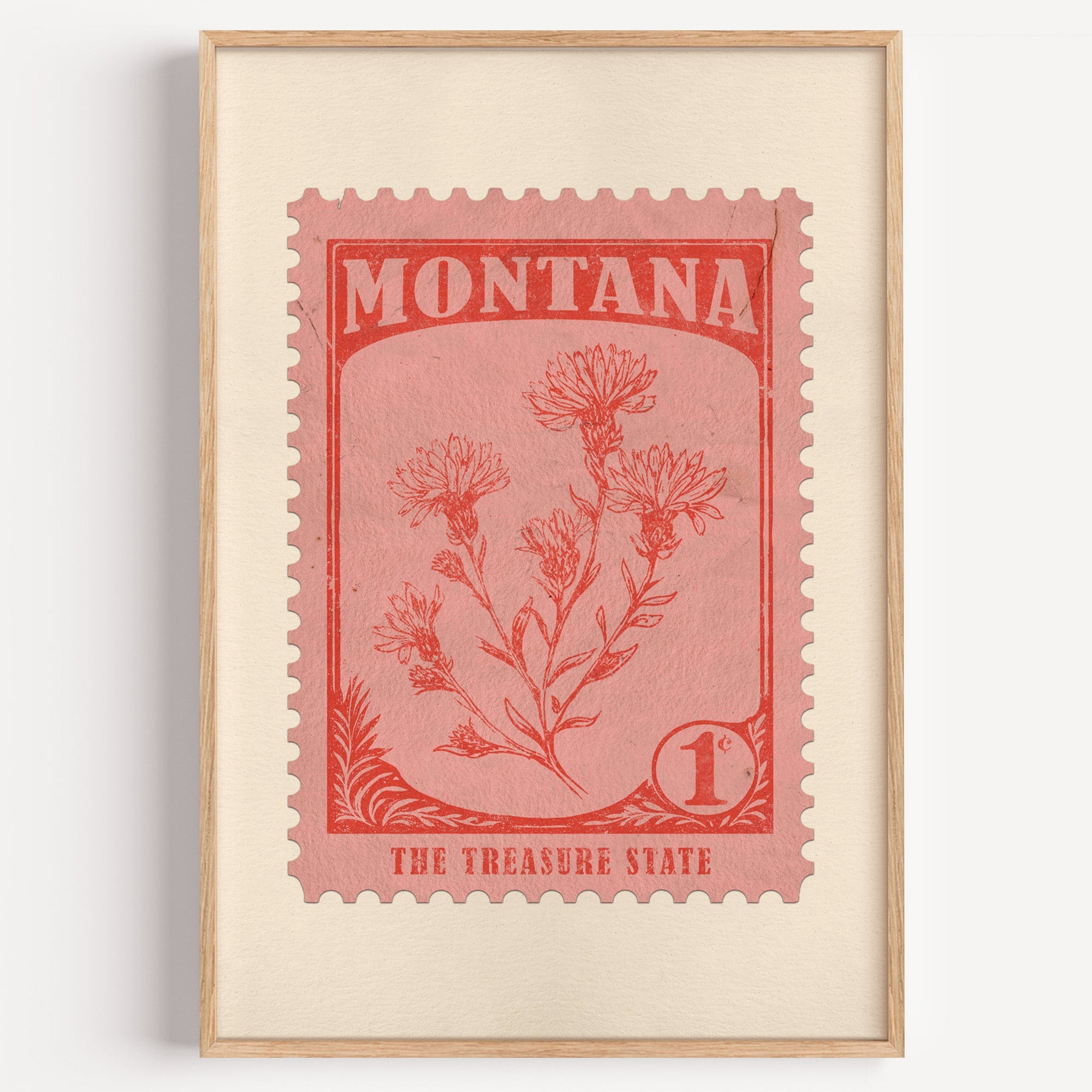 Montana state flower stamp print in vermilion on warm pink, light oak frame on a plain white wall