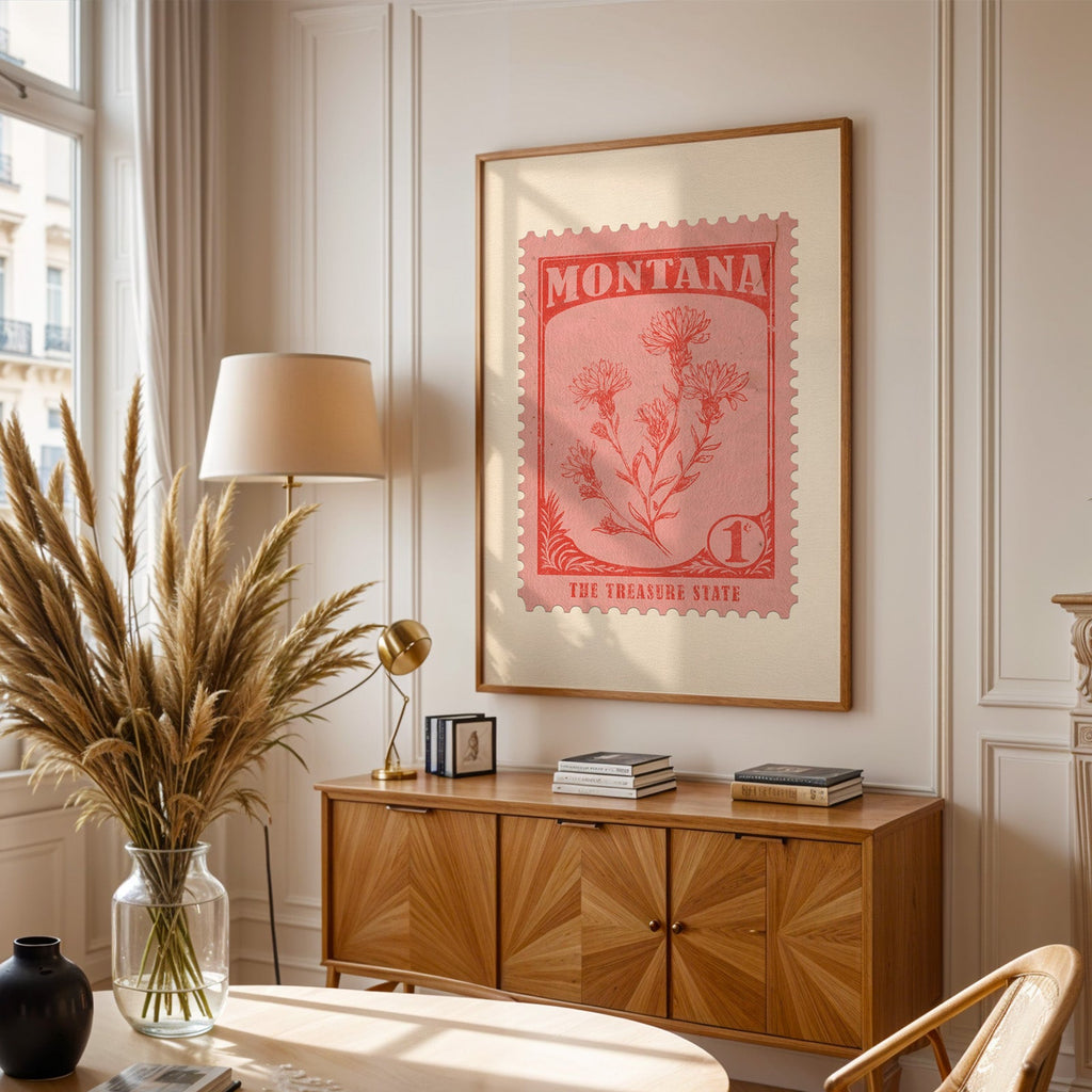 Montana stamp print framed above a wooden sideboard, pampas grass in a glass vase and a floor lamp