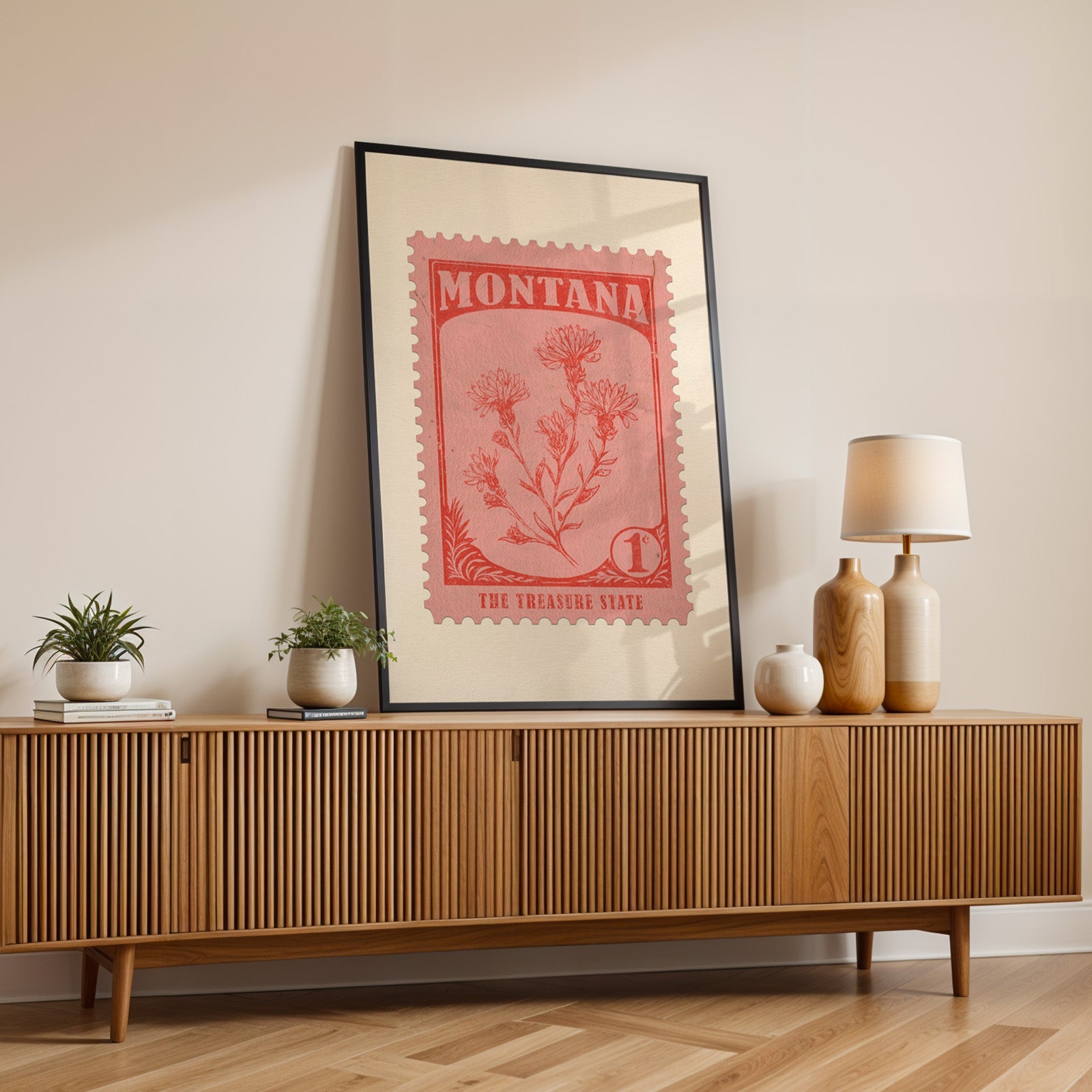 Montana state flower print in a black frame leaning on a fluted wood credenza with vases and a lamp