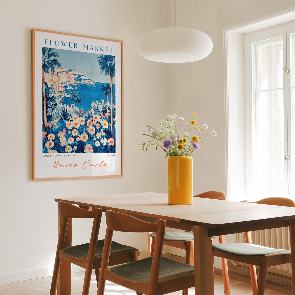 Monte Carlo flower market print in an oak frame above a dining table with a yellow vase and white pendant light