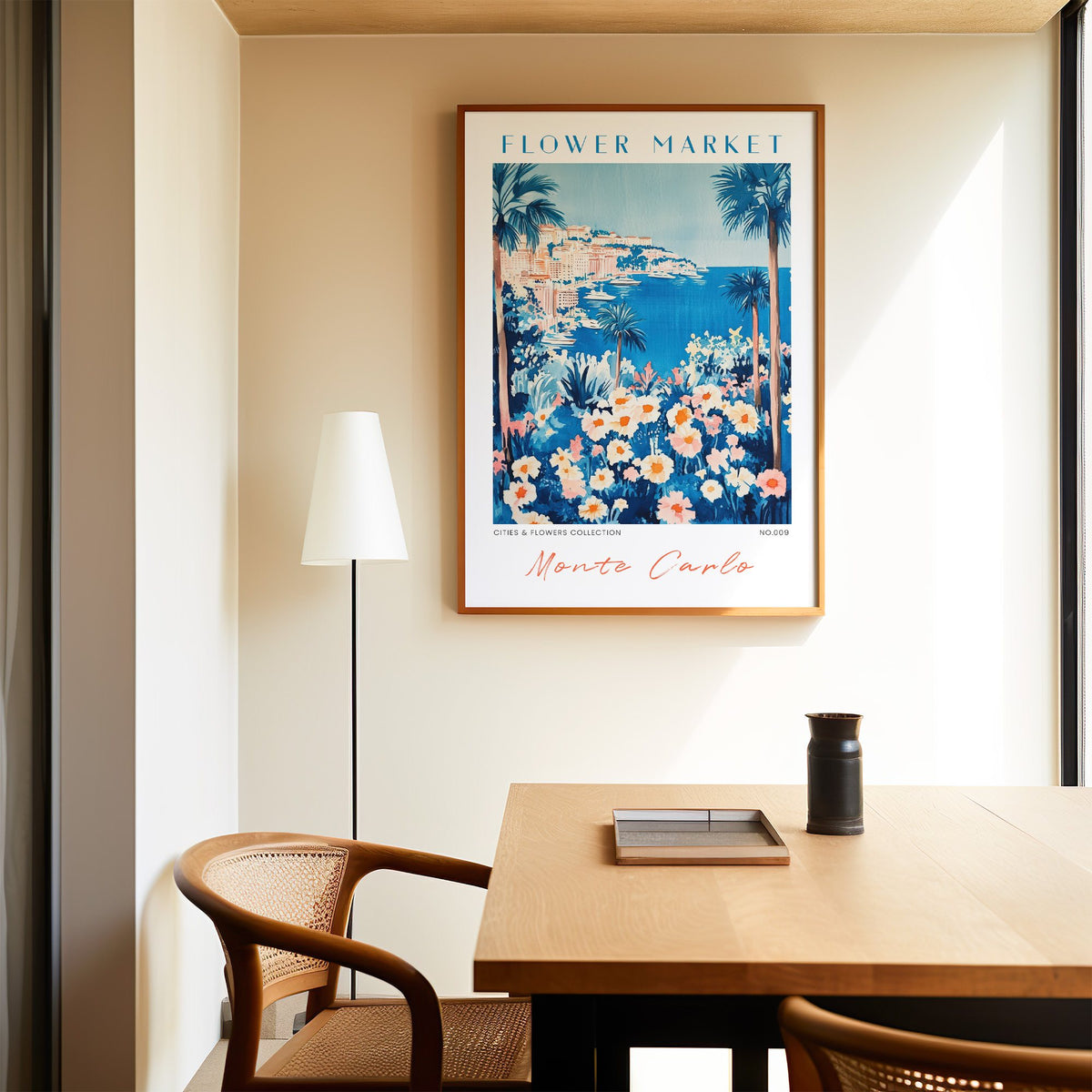 Monte Carlo flower market print in an oak frame above a dining table and cane chair