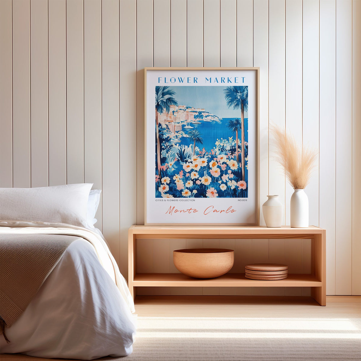 Monte Carlo flower market print in an oak frame on a wood bench against a white shiplap bedroom wall with pampas grass