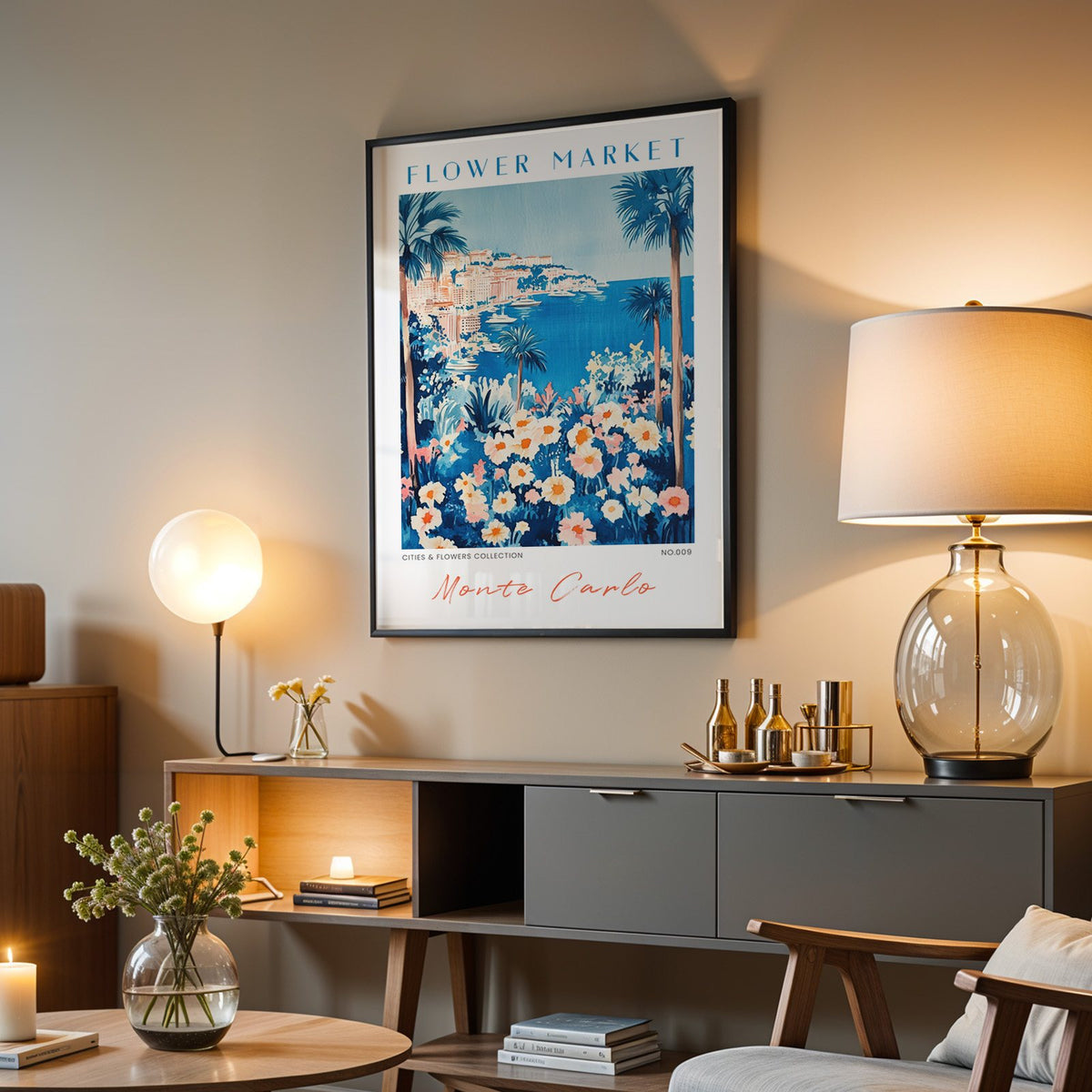 Monte Carlo flower market print in a black frame above a grey media console with a glass table lamp