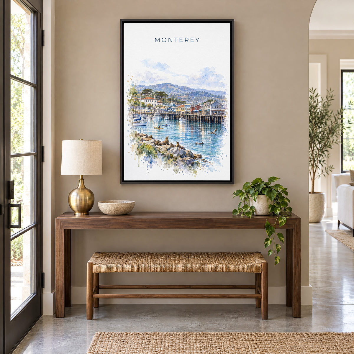 Monterey watercolor print as a black floater canvas above a walnut console and woven bench in an entryway