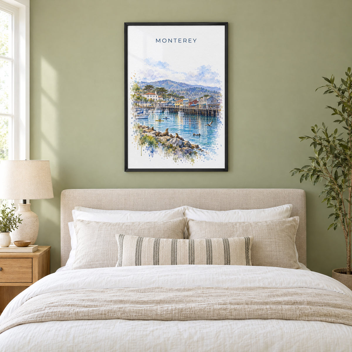 Monterey watercolor print in a black frame above an upholstered headboard in a sage green bedroom