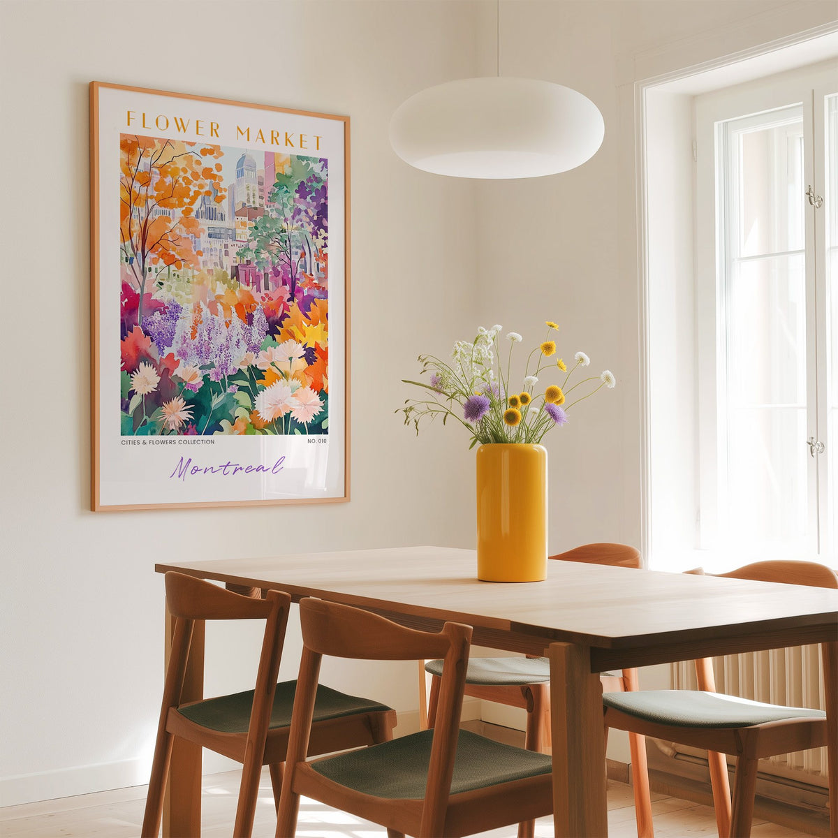 Montreal flower market print in an oak frame above a dining table with a yellow vase and white pendant light