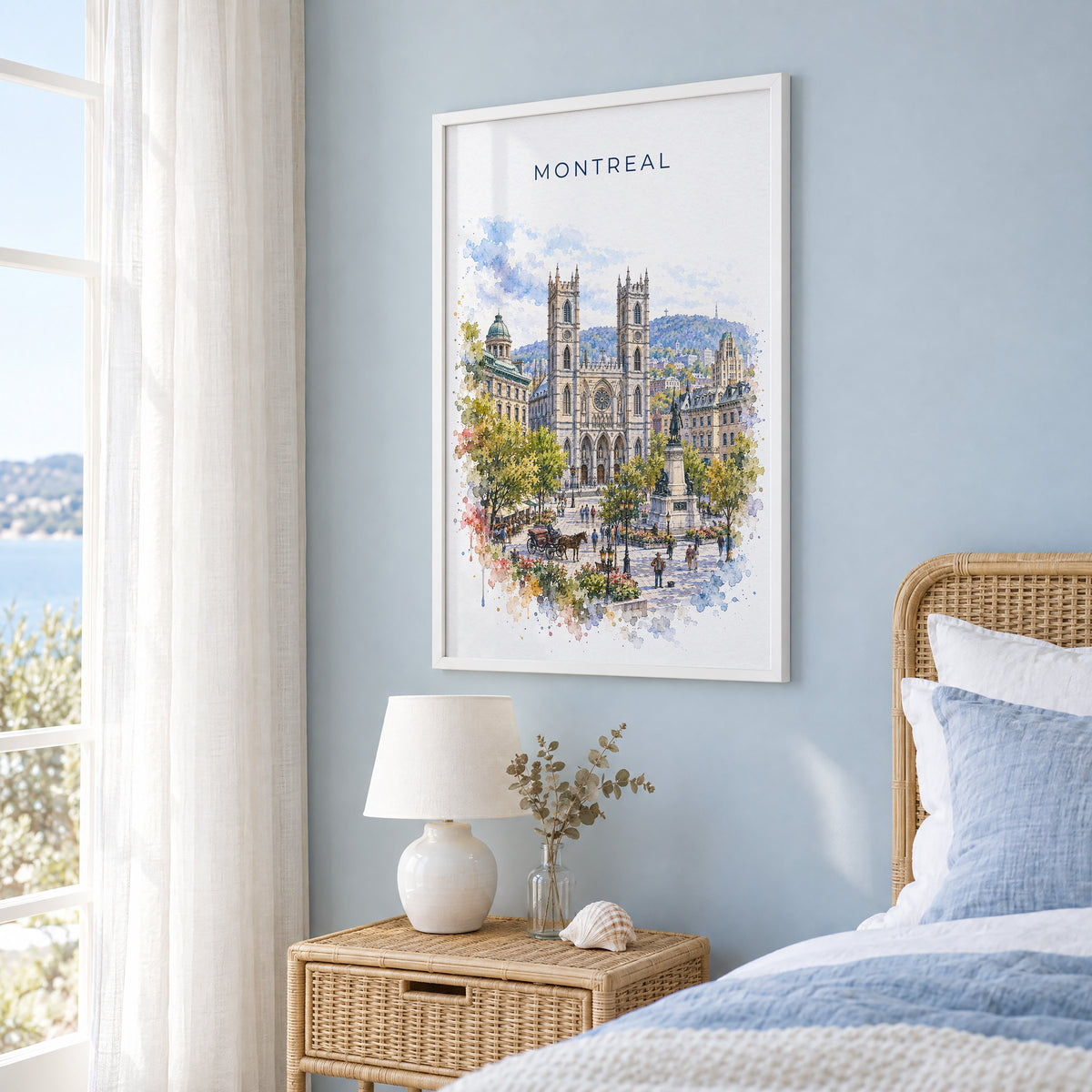 Montreal watercolor print in a white frame on a pale blue wall beside a rattan bed in a coastal bedroom