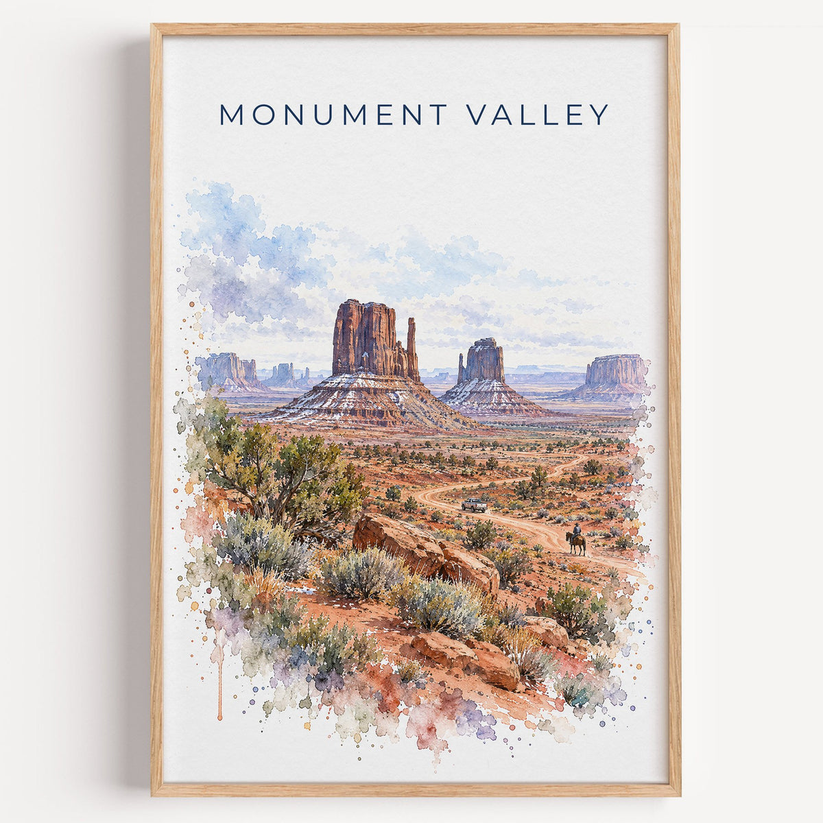 Monument Valley watercolor print in a light oak frame on a plain white wall
