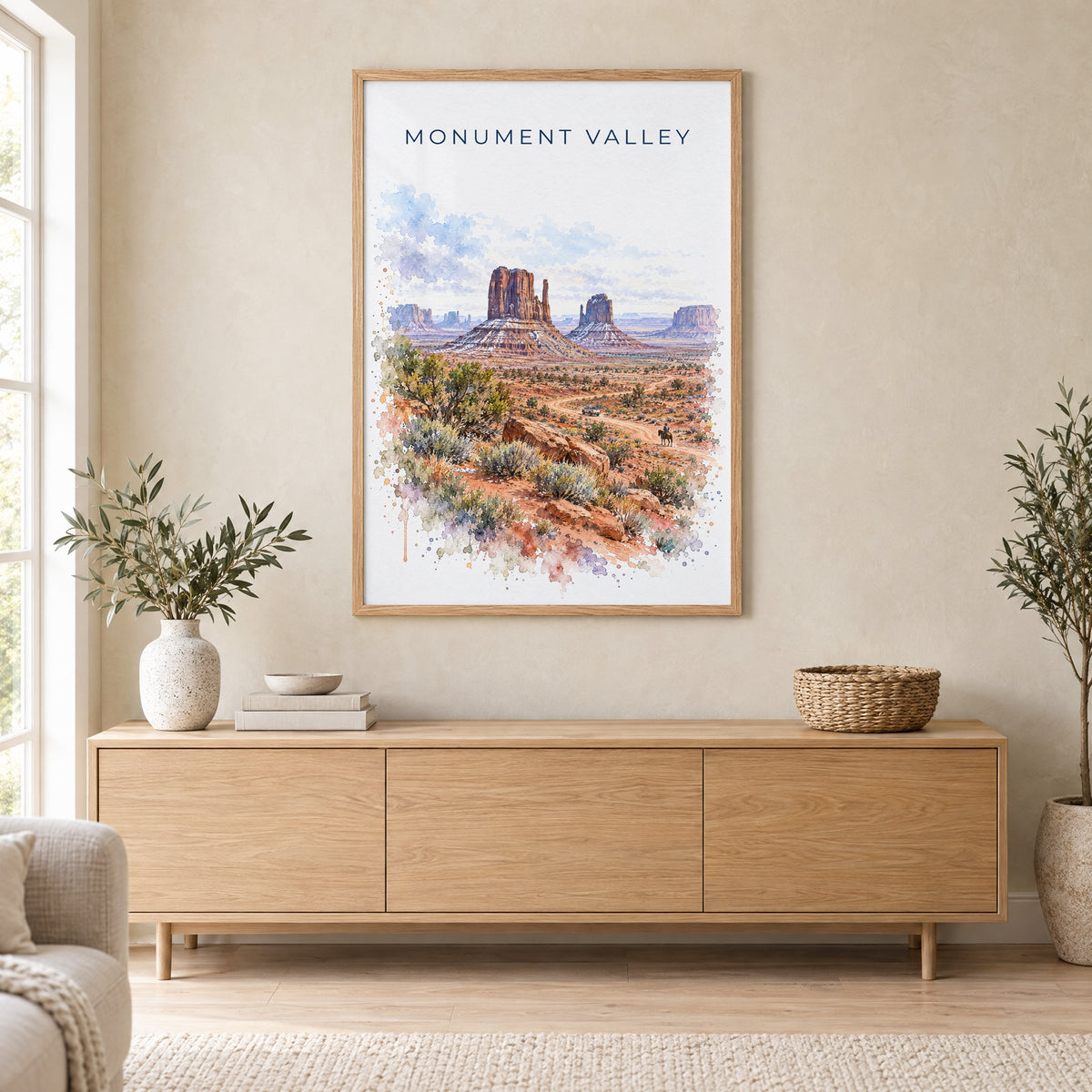 Monument Valley watercolor print in an oak frame above a light wood sideboard in a Scandinavian living room